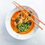 Thai red curry noodle soup with shiitake, coconut milk and onions