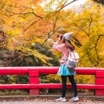 Young woman traveler looking and photographing beautiful autumn in Japan, Travel lifestyle concept